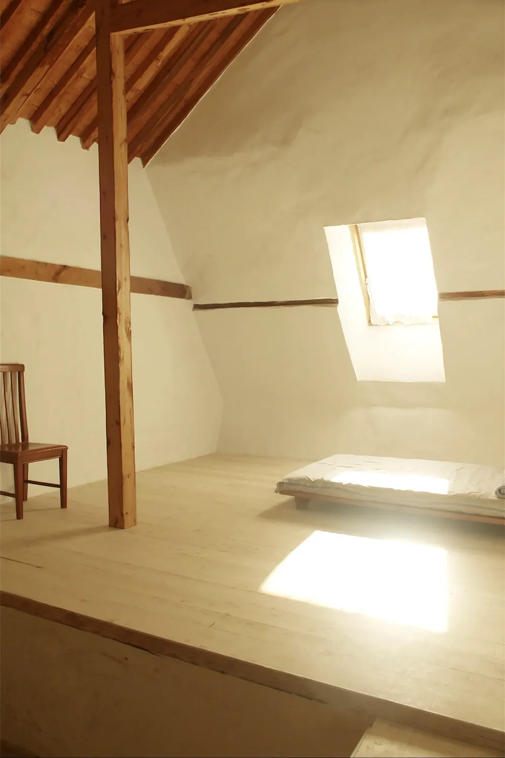 A Mansarde room: sloping ceiling, exposed beams.